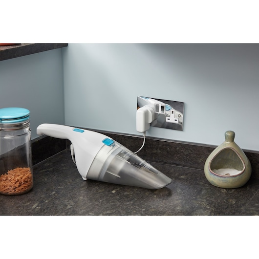 BLACKDECKER NVC115JL handheld vacuum cleaner charging on kitchen counter, side angle.