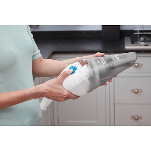 Photo of BLACKDECKER NVC115JL handheld vacuum being opened for cleaning in a kitchen setting.
