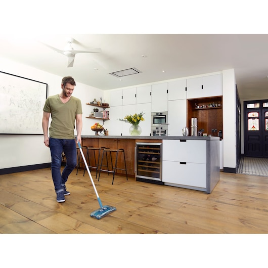 BLACKDECKER PSA115B floor mop used in modern kitchen with wood flooring, front angle.
