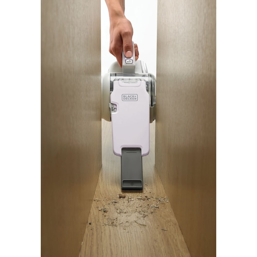 BLACKDECKER PV1820LRGP handheld vacuum cleaning debris between wooden panels, shown from front angle.