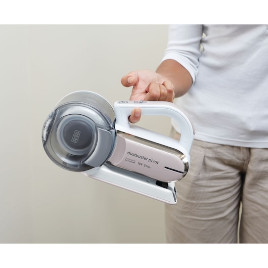 Photo of BLACK+DECKER PV1820LRGP handheld cordless vacuum, white and grey, held in hand, side view.