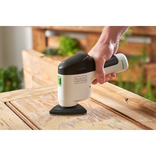 BLACKDECKER REVDS12C detail sander in use on wooden surface, close-up angle.