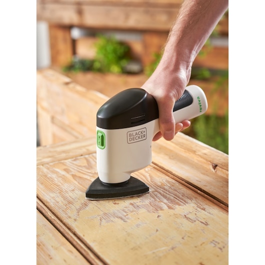 BLACKDECKER REVDS12C detail sander in use on wood surface, close-up view.