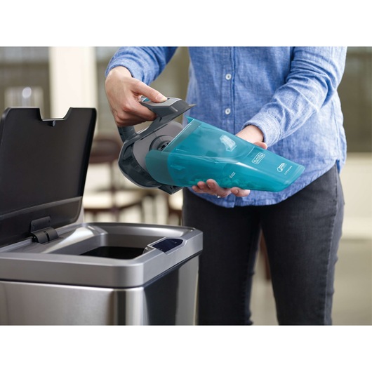 Photo of BLACKDECKER WDA320J handheld vacuum being emptied into a trash bin.